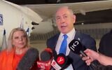 Prime Minister Benjamin Netanyahu, with his wife Sara at his side, speaks to reporters as they prepare to board a plane for the US early Monday, September 18, 2023. (Channel 12 screenshot)