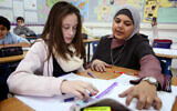 Arab-Israeli teacher, Nedaa Rabie, helps student, Adi Hevlin, in her classroom at the Gvanim Junior Highschool in Qadima on Thursday, December 26, 2013. The Gvanim Junior Highschool currently employs five Arab teachers and serves as a successful example of the Education Ministry's program for integrating Arab school teachers in the Jewish sector. (Hadas Parush/Flash 90)