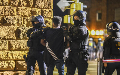 A man is taken away by police officers in Stuttgart, Baden-Württemberg, Germany, on Saturday, Sept. 16, 2023, after clashes at a gathering of Eritrean groups. (Jason Tschepljakow/dpa via AP)