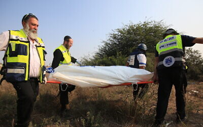 Medical responders carry a body bag in Sderot, Israel, Oct. 8, 2023. (Saeed Qaq/Anadolu Agency via Getty Images / via JTA)