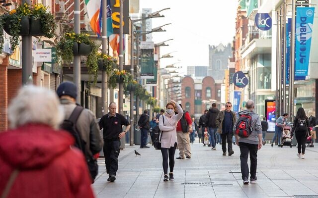 Illustrative: People walk past shops in Dublin on March 25, 2020. (Paul Faith/AFP)