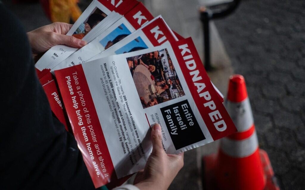 An Israeli activist prepares to put up posters near New York City’s Union Square subway station, October 16, 2023. (Luke Tress/ JTA)