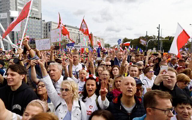 Demonstrators react as Polish opposition leader, former premier and head of the centrist Civic Coalition bloc, Donald Tusk (not pictured) addresses participants of a rally in Warsaw on October 1, 2023. (Wojtek Radwanski/AFP)