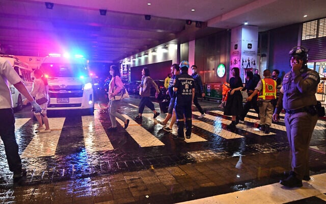 Emergency workers and police direct people leaving Siam Paragon shopping center in Bangkok on October 3, 2023, following a shooting incident in the mall. (Lillian Suwanrumpha/AFP) Emergency workers and police direct people leaving Siam Paragon shopping center in Bangkok on October 3, 2023, following a shooting incident in the mall. (Lillian Suwanrumpha/AFP)