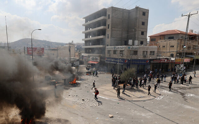 Smoke billows from burning tires as Palestinians clash with Israeli troops in the northern West Bank town of Huwara on October 6, 2023, following a funeral for a Palestinian man who the military says soldier shot for throwing a cinderblock at an Israeli-driven vehicle. (Jaafar Ashtiyeh/AFP) Smoke billows from burning tires as Palestinians clash with Israeli troops in the northern West Bank town of Huwara on October 6, 2023, following a funeral for a Palestinian man who the military says soldier shot for throwing a cinderblock at an Israeli-driven vehicle. (Jaafar Ashtiyeh/AFP)