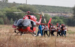 Israeli rescue teams evacuate a wounded person by helicopter near the southern city of Sderot on October 7, 2023 (Menahem KAHANA / AFP)
