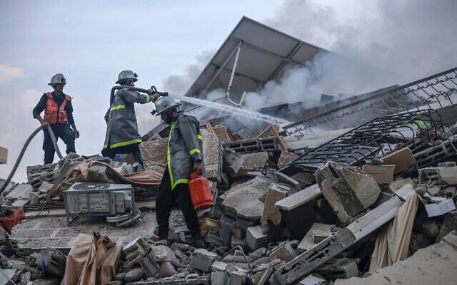 Palestinian firemen extinguish a fire that was raging in a building destroyed by Israeli airstrikes in Gaza City on October 8, 2023. (MOHAMMED ABED / AFP)