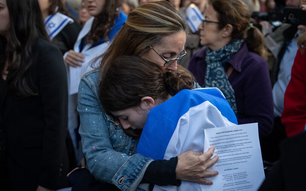 Illustrative: Miriam Herman embraces Noa Herman, aged 12, as people attend a prayer service and candlelight vigil for Israel at Temple Emanu-El in New York City on October 9, 2023, after the Palestinian terror group Hamas launched an attack. (Adam Gray/AFP)