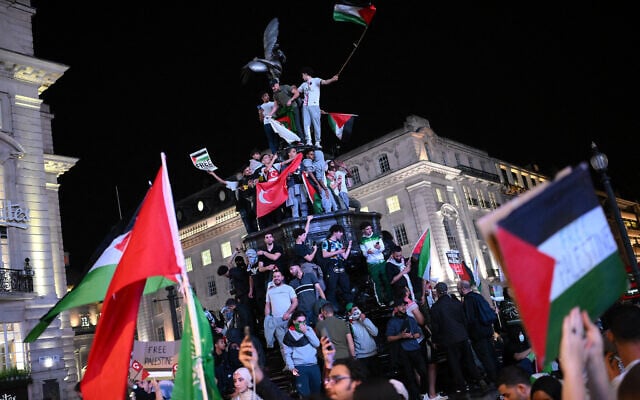 Pro-Palestinian supporters wave flags and hold placards as they demonstrate at Piccadilly Circus in London on October 9, 2023.(Daniel LEAL / AFP)