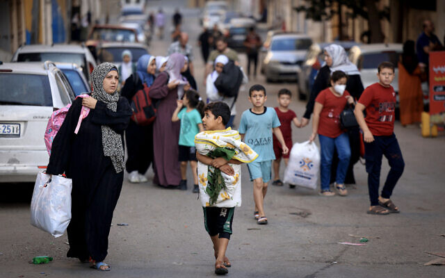 Palestinians carrying their belongings flee to safer areas in Gaza City after Israeli air strikes, on October 13, 2023. (MAHMUD HAMS / AFP)