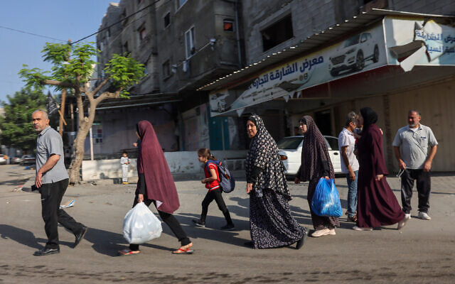 Palestinians carrying their belongings flee to safer areas in Gaza City after Israeli air strikes, on October 13, 2023. (MOHAMMED ABED / AFP) Palestinians carrying their belongings flee to safer areas in Gaza City after Israeli air strikes, on October 13, 2023. (MOHAMMED ABED / AFP)