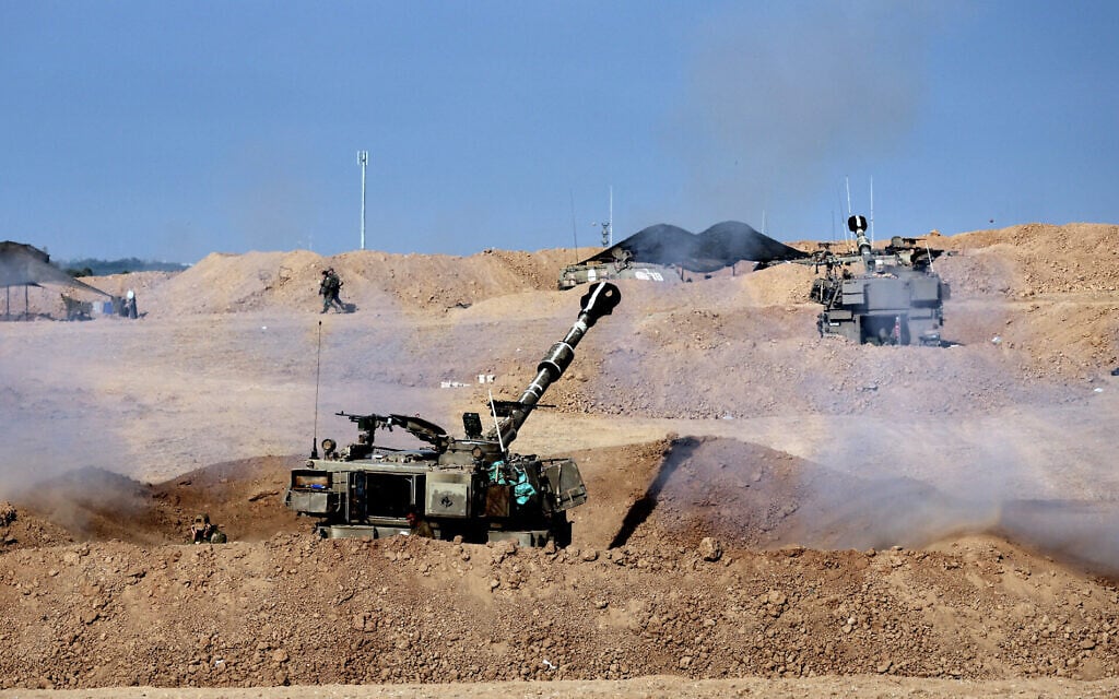 Israeli artillery fires towards the Gaza Strip enclave, from a field near the Israeli city of Sderot, on October 14, 2023. (Thomas Coex/AFP)