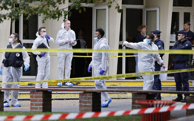 French police officers from the forensic service stand in front of the Gambetta high school in Arras, northeastern France on October 13, 2023, after a teacher was killed and two other people severely wounded in a knife attack, police and regional officials said.  (Photo by Ludovic MARIN / POOL / AFP)