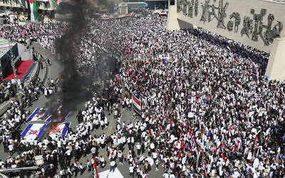 Protesters burn Israeli flags during a demonstration at Tahrir Square in Baghdad on October 13, 2023 (Ahmad Al-Rubaye / AFP)