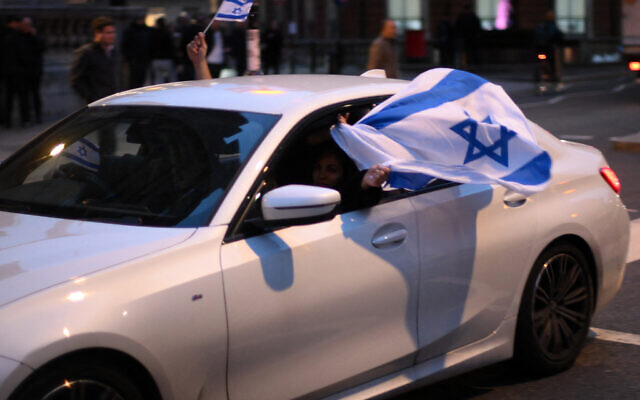Protesters wave Israeli flags at a gathering outside the headquarters of the BBC (British Broadcasting Corporation) in London on October 16, 2023, denouncing the corporation for failing to refer to Hamas as a terror group. (Daniel LEAL / AFP)