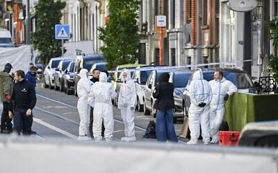 Belgian police officers investigate the scene where the suspected perpetrator of a terror shooting was killed, in the Schaerbeek area of Brussels on October 17, 2023. (JOHN THYS/AFP)