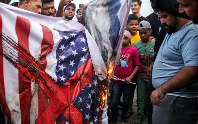 Demonstrators burn banners showing the US and Israeli flags during a demonstration in solidarity with the Palestinian people in the Gaza Strip, in Iraq's southern city of Basra on October 20, 2023. (Hussein Faleh/AFP) Demonstrators burn banners showing the US and Israeli flags during a demonstration in solidarity with the Palestinian people in the Gaza Strip, in Iraq's southern city of Basra on October 20, 2023. (Hussein Faleh/AFP)