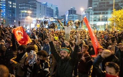 People take part in a protest outside the Israeli consulate to show solidarity with Palestinians, in Istanbul early on October 18, 2023. (Umit Turhan Coskun/AFP)