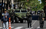 Police officers stand guard on Mayo Avenue in Buenos Aires after the Israeli embassy received a bomb threat, Oct. 18, 2023 (Luis ROBAYO / AFP)