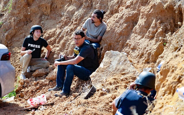 Journalists take cover upon hearing warning sirens in the southern Israeli city of Sderot on the border with the Gaza Strip on October 20, 2023, amid the ongoing battles between Israel and the Palestinian terror group Hamas. (Photo by Jack Guez / AFP) Journalists take cover upon hearing warning sirens in the southern Israeli city of Sderot on the border with the Gaza Strip on October 20, 2023, amid the ongoing battles between Israel and the Palestinian terror group Hamas. (Photo by Jack Guez / AFP)