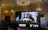 Journalists watch a large screen showing United Nations Secretary-General Antonio Guterres attending the International Peace Summit hosted by the Egyptian president in Cairo on October 21, 2023. (Khaled Desouki/AFP)