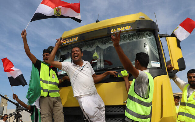 Egyptian aid workers celebrate as an aid truck crosses back into Egypt through the Rafah border crossing with the Gaza Strip on October 21, 2023. (Kerolos Salah/AFP)