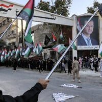 Palestinian members of Islamic Jihad stand in line holding Palestinian flags during a rally at the Yarmouk refugee camp south of Syria's capital Damascus on October 21, 2023. (LOUAI BESHARA / AFP)