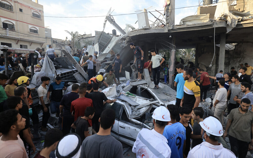 Illustrative: Palestinians inspect debris after an Israeli strike near a UNRWA school in Khan Younis, in the southern Gaza Strip on October 21, 2023. (Mahmud HAMS / AFP)