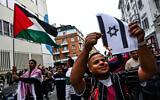 A protester sets the Israeli flag on fire during a pro-Palestinian rally in Milan, Italy, on October 21, 2023. (Piero CRUCIATTI/AFP)