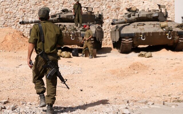 Israeli soldiers gather near Merkava tanks as they man a position at an undisclosed location on the border with Lebanon on October 22, 2023. (Jalaa MAREY / AFP) Israeli soldiers gather near Merkava tanks as they man a position at an undisclosed location on the border with Lebanon on October 22, 2023. (Jalaa MAREY / AFP)