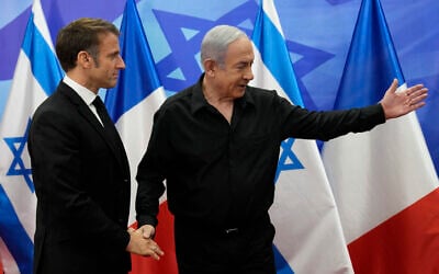 Prime Minister Benjamin Netanyahu (R) greets French President Emmanuel Macron before a meeting in Jerusalem on October 24, 2023. (Photo by Christophe Ena / POOL / AFP)