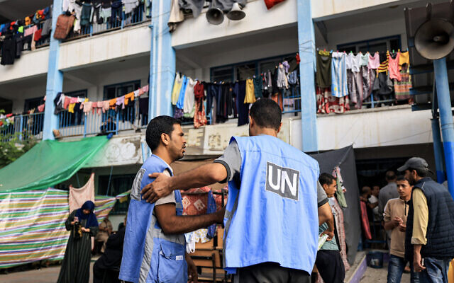 Workers of the United Nations Relief and Works Agency for Palestine Refugees (UNRWA) agency talk together in the playground of an UNRWA-run school that has been converted into a shelter for displaced Palestinians in Khan Younis in the southern Gaza Strip on October 25, 2023. (Mahmud HAMS/AFP) Workers of the United Nations Relief and Works Agency for Palestine Refugees (UNRWA) agency talk together in the playground of an UNRWA-run school that has been converted into a shelter for displaced Palestinians in Khan Younis in the southern Gaza Strip on October 25, 2023. (Mahmud HAMS/AFP)
