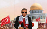 Illustrative: Turkish President Recep Tayyip Erdogan, wearing a scarf with the Palestinian and Turkish flags, stands on the stage during a rally organized by his ruling AKP party in solidarity with the Palestinians in Gaza, in Istanbul on October 28, 2023. (Handout/Turkish Presidency Press Office/AFP)
