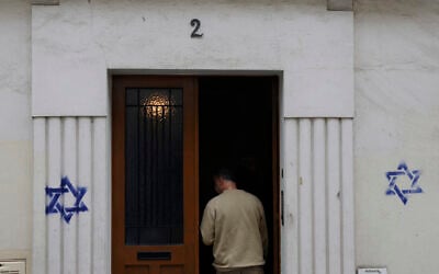 A man enters a building whose facade was covered with Stars of David painted during the night, in the Alesia district of Paris, on October 31, 2023. (Geoffroy Van der Hasselt / AFP) A man enters a building whose facade was covered with Stars of David painted during the night, in the Alesia district of Paris, on October 31, 2023. (Geoffroy Van der Hasselt / AFP)
