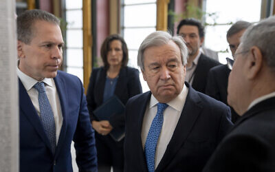 UN Ambassador Gilad Erdan, left, UN Secretary-General Antonio Guterres, center, and Yad Vashem Chairman Dani Dayan browse the Yad Vashem Book of Names of Holocaust Victims Exhibit at United Nations headquarters, January 26, 2023. (AP Photo/John Minchillo)