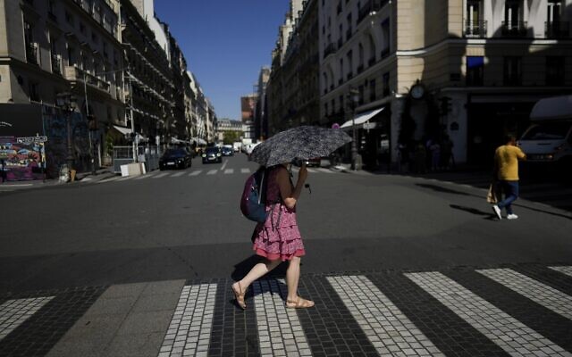 File: A woman holds an umbrella to protect herself from the sun, in Paris, September 6, 2023. (AP Photo/Thibault Camus, File)