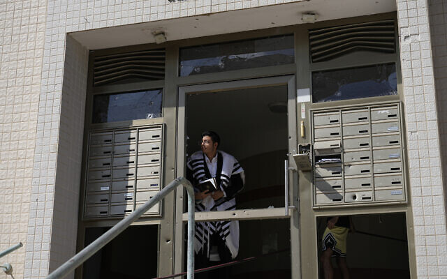 An ultra-Orthodox Jew peers out of a building after a rocket attack from the Gaza Strip in Ashkelon, October 7, 2023. (AP Photo/Ohad Zwigenberg) An ultra-Orthodox Jew peers out of a building after a rocket attack from the Gaza Strip in Ashkelon, October 7, 2023. (AP Photo/Ohad Zwigenberg)