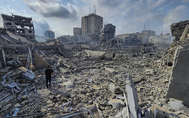 Palestinians walk through the rubble of buildings destroyed by Israeli airstrikes in Gaza City on Tuesday, Oct. 10, 2023. (AP Photo/Hassan Eslaiah)