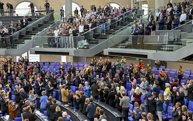 Lawmakers applaud to Ron Prosor, Israel's ambassador to Germany, left, and Germany's President Frank-Walter Steinmeier, front row on right balcony, at the German parliament Bundestag in Berlin, Germany, Wednesday, Oct.11, 2023. (AP Photo/Stefanie Loos)