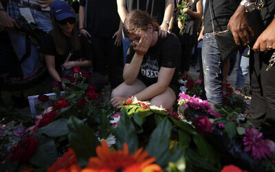 Israelis mourn next to the graves of Danielle Waldmann and her partner Noam Shai, during their funeral in the northern Israeli town of Kiryat Tivon, October 12, 2023. (AP Photo/Ariel Schalit)