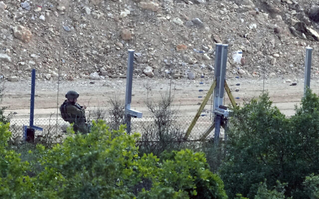 An Israeli soldier adds a new fence alongside the border wall with Lebanon as seen from the Lebanese side of the Lebanese-Israeli border in the southern village of Marwaheen, Lebanon, Friday, Oct. 13, 2023.(AP Photo/Hassan Ammar) An Israeli soldier adds a new fence alongside the border wall with Lebanon as seen from the Lebanese side of the Lebanese-Israeli border in the southern village of Marwaheen, Lebanon, Friday, Oct. 13, 2023.(AP Photo/Hassan Ammar)