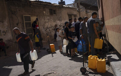 Palestinians collect water from a water tap, amid drinking water shortages, in Khan Younis, Gaza Strip, Oct. 15, 2023. (AP Photo/Fatima Shbair)