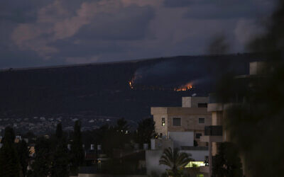 A fire burns on the Israeli side of the border with Lebanon following explosions, Sunday, Oct. 15, 2023. (AP Photo/Petros Giannakouris)