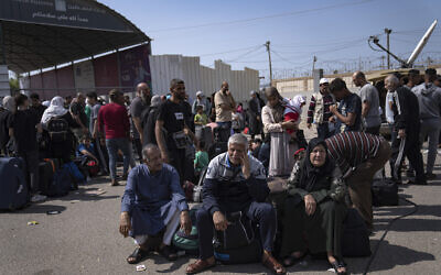 Palestinians wait to cross into Egypt at the Rafah border crossing in the Gaza Strip on October 16, 2023. (AP Photo/Fatima Shbair)