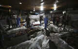 Bodies of Palestinians killed by an explosion near the Ahli Arab hospital are gathered in the front yard of the al-Shifa hospital, in Gaza City, central Gaza Strip, October 17, 2023. Israel said the explosion was caused by a rocket misfire by Palestinian terrorists, denying Hamas claims of an Israeli airstrike. (AP/Abed Khaled)