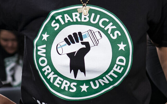 The Starbucks Workers United logo appears on the shirt of a person attending a hearing in Washington on March 29, 2023. (J. Scott Applewhite/AP) The Starbucks Workers United logo appears on the shirt of a person attending a hearing in Washington on March 29, 2023. (J. Scott Applewhite/AP)