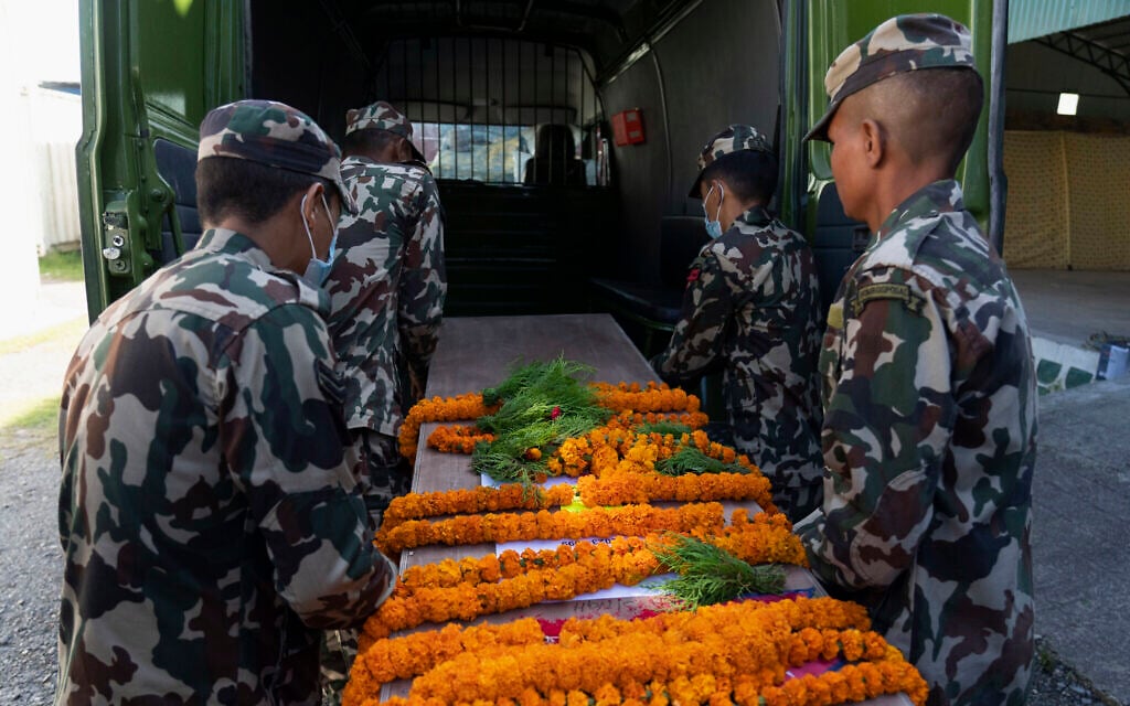 Army personnel carry one of the coffins containing bodies of Nepali nationals who were killed by Hamas terrorists in Israel, at Tribhuvan International Airport in Kathmandu, Nepal, Oct. 22, 2023 (AP Photo/Niranjan Shrestha)
