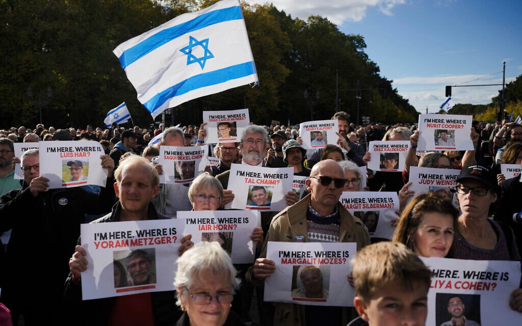 People wave Israeli flags and show posters from people reported to be missing or held by Hamas as hostages, during a demonstration against antisemitism and to show solidarity with Israel in Berlin, Germany, October 22, 2023. (AP Photo/Markus Schreiber)