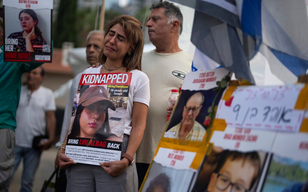 An Israeli woman cries as she holds a photo of a woman who was kidnapped, during a rally calling for the return of more than 200 people captured by Hamas, in Tel Aviv, Israel, Monday, Oct. 23, 2023. (AP/Petros Giannakouris)