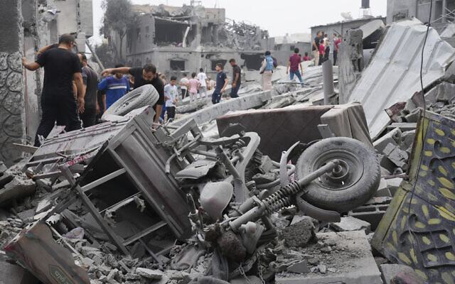 Palestinians walk about buildings destroyed in Israeli strikes on the Nusseirat refugee camp in the Gaza Strip on Oct. 29, 2023. (AP Photo/Hatem Moussa)